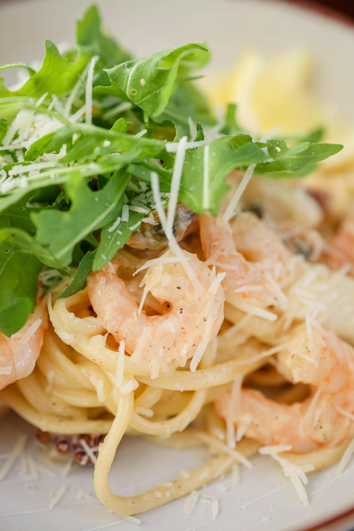 Delicious creamy shrimp pasta topped with fresh arugula and grated Parmesan cheese.