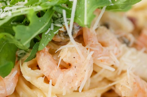 Delicious creamy shrimp pasta topped with fresh arugula and grated Parmesan cheese.